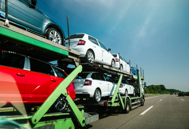 Germany - May 11, 2018: View of long truck transporting new cars and riding on highway in sunlight under blue sky - generic cars for fast delivery to the client